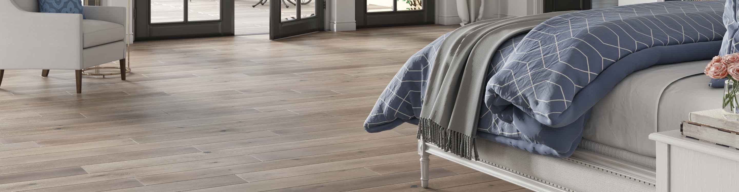 hardwood floors in a bedroom with bed, blue sheets, and mirror
