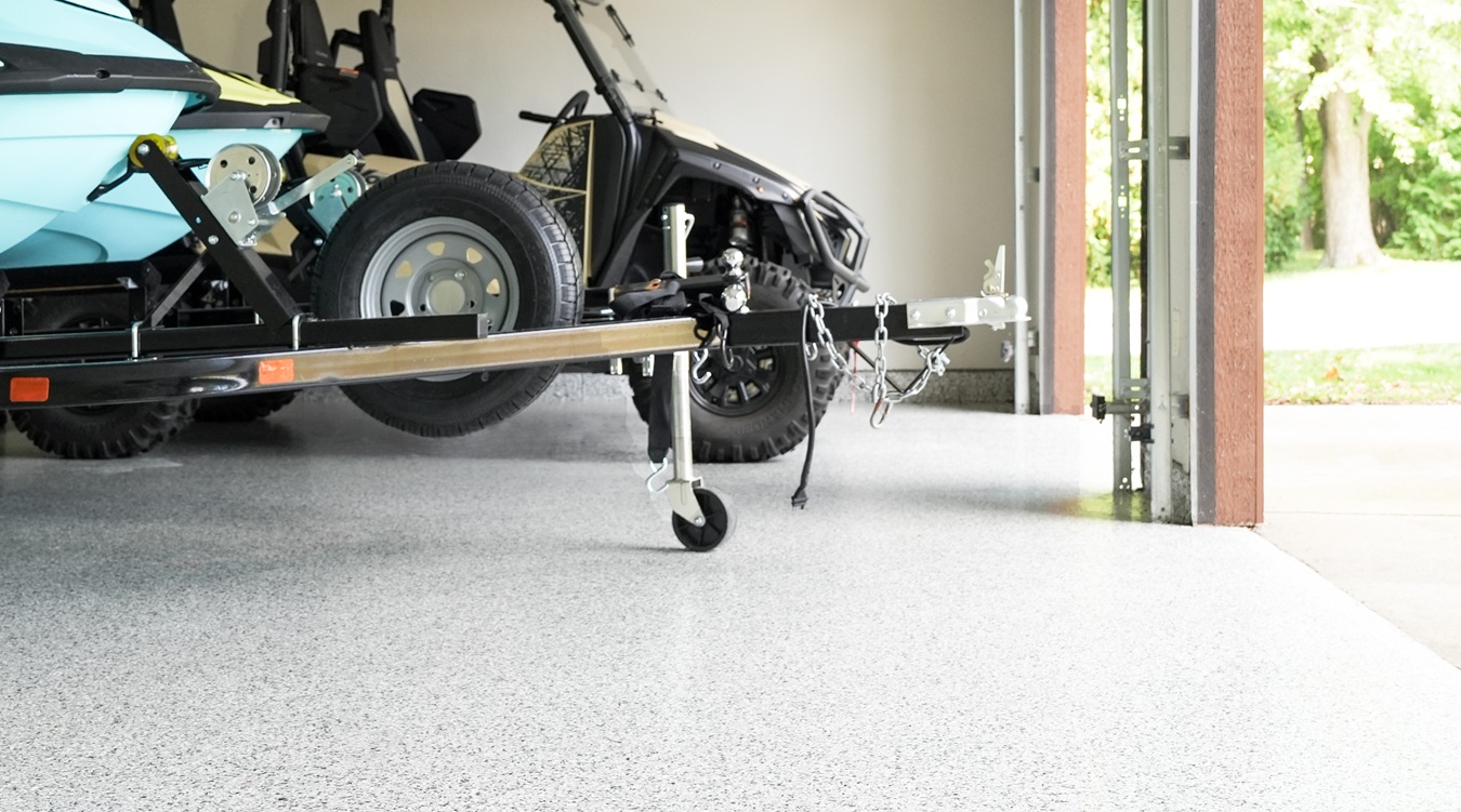 A trailer hitch resting on a clean, epoxy garage floor.