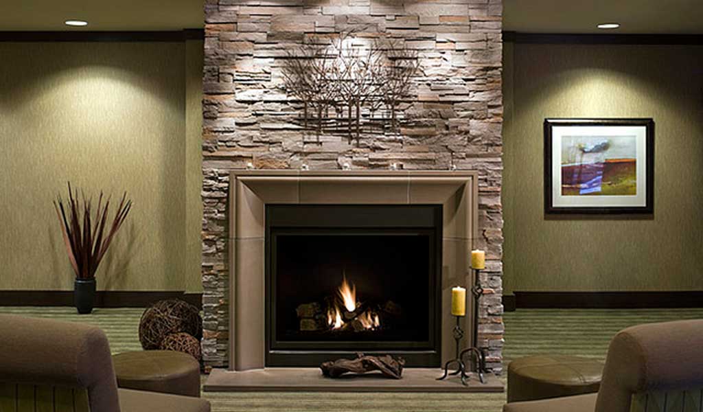 12 Cozy & Beautiful Fireplaces http://www.beautifuldesignmadesimple.com natural stone fireplace in a cozy room with green textured carpet Photo: Home Designing